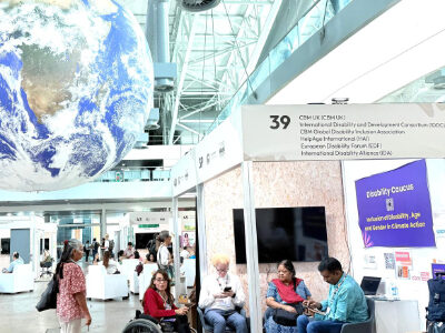 Reena Mohanty with others at Disability Caucus booth, COP 30.