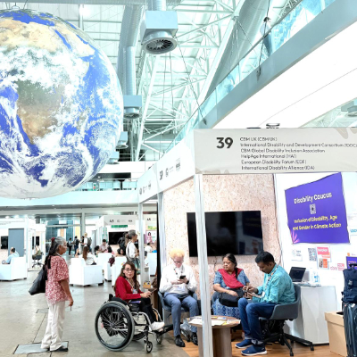 Reena Mohanty with others at Disability Caucus booth, COP 30.